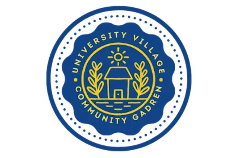 Photo of a blue circular logo with a yellow house and the text "University Village Community Garden" inside the logo