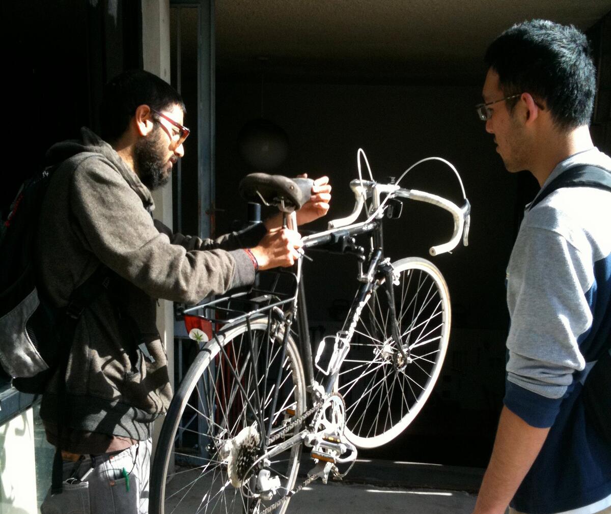 Person holds bike attempting to fix seat