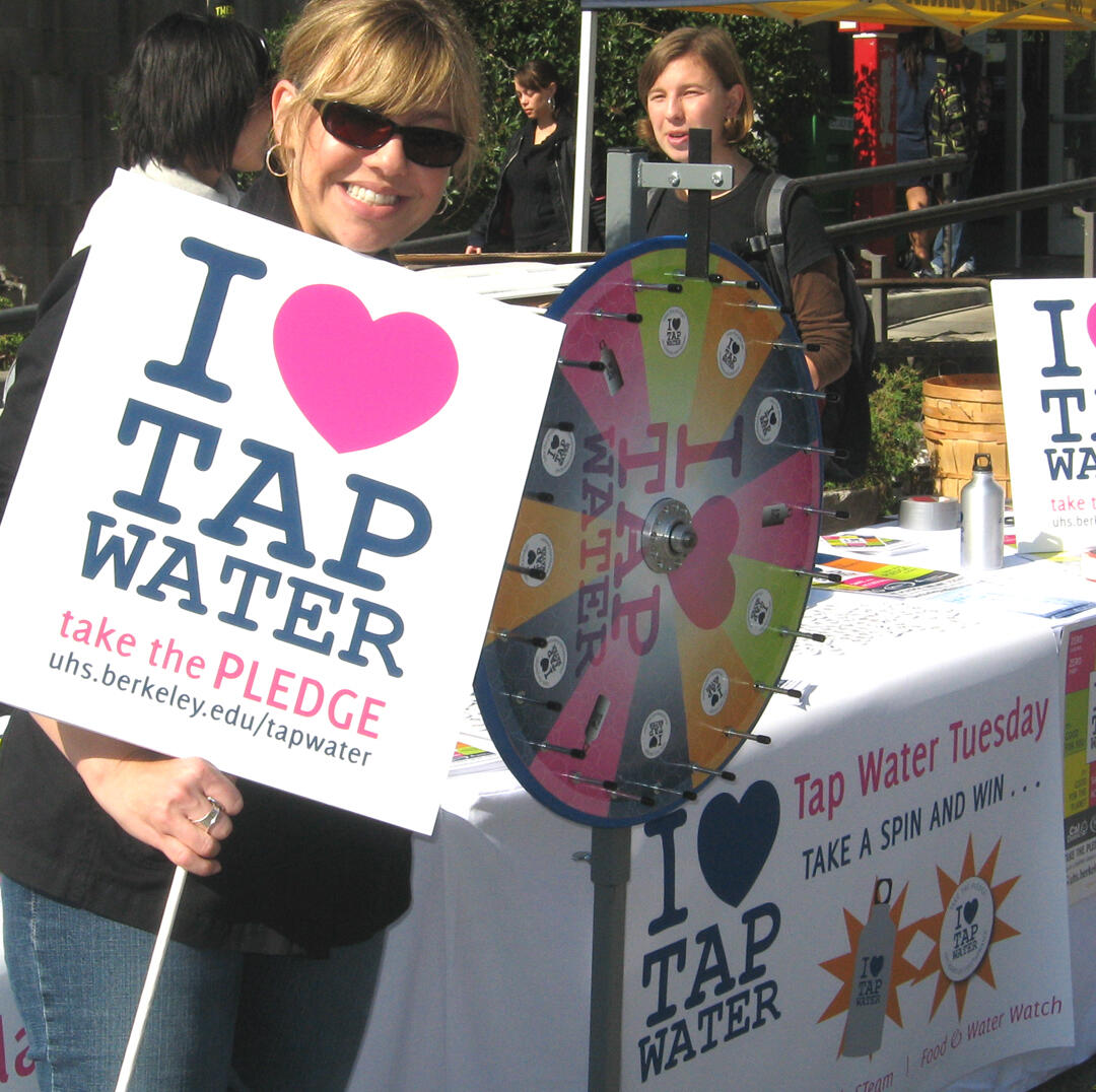 This is Kim Lapean holding a I heart tap water sign